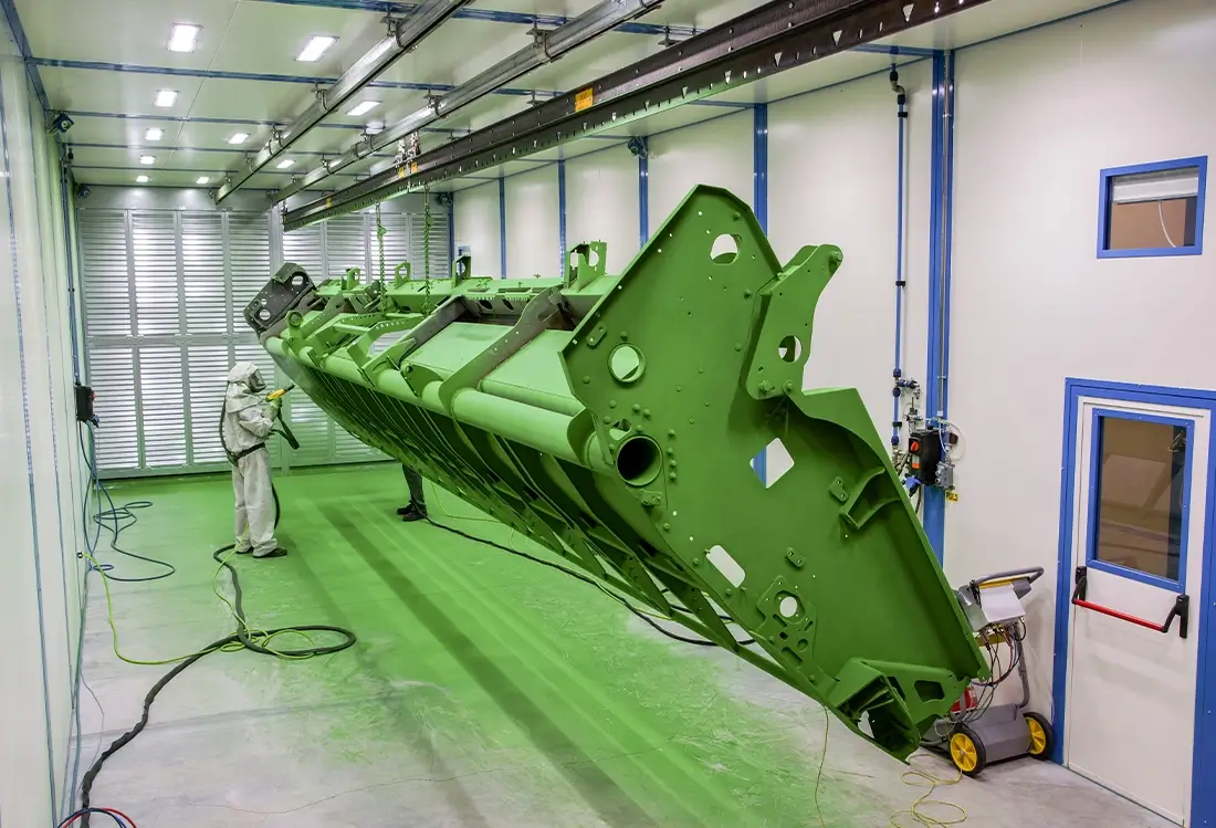 Mann lackiert Schneidwerk grün