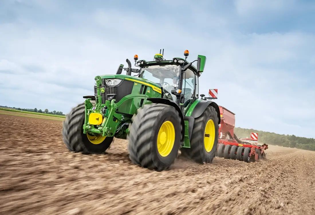 John Deere Traktor auf dem kahlen Acker