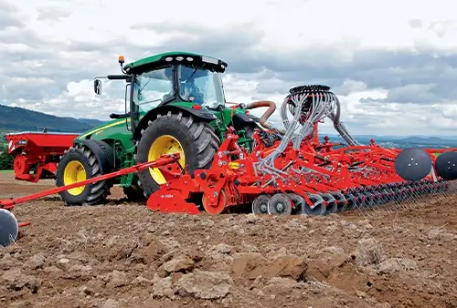 Maschine hinter Traktor auf dem Feld