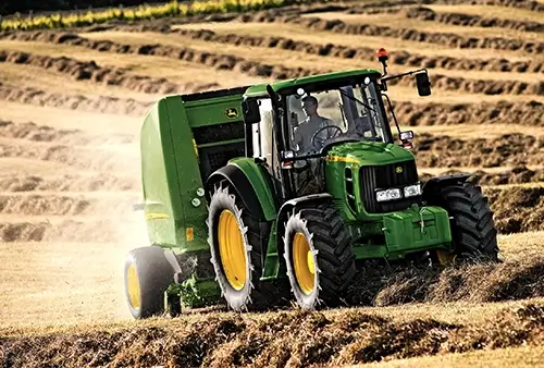 John Deere Landmaschine bei der Bodenbearbeitung auf dem Acker