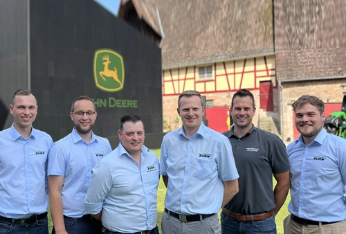 Gruppenbild Zürn Landtechnik Mitarbeiter vor John Deere Logo auf dem Hof