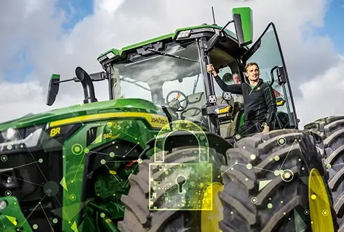 Mann an der Tür des Traktors John Deere 8R Froschperspektive